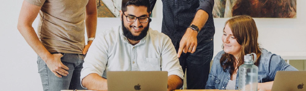 Co-workers working at a laptop computer discussing accessibility issues