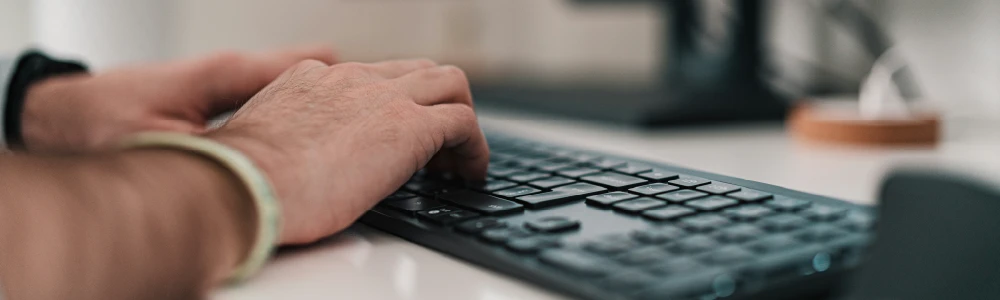 Man typing on a computer keyboard